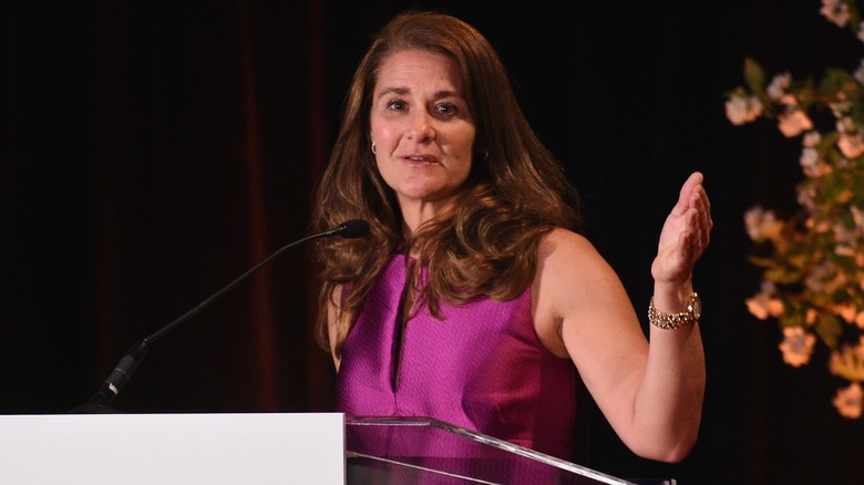 Melinda Gates addresses an audience, gesturing with one hand.
