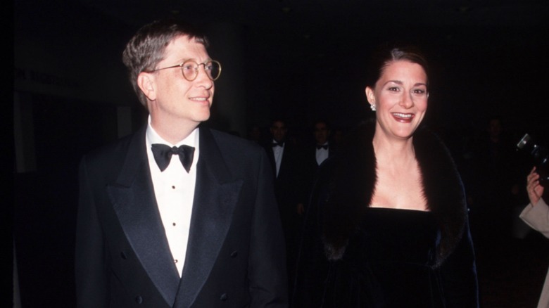 Bill and Melinda Gates walk side by side in coordinated black outfits.