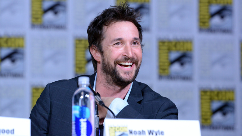 Noah Wyle smiling while at a Comic Con panel