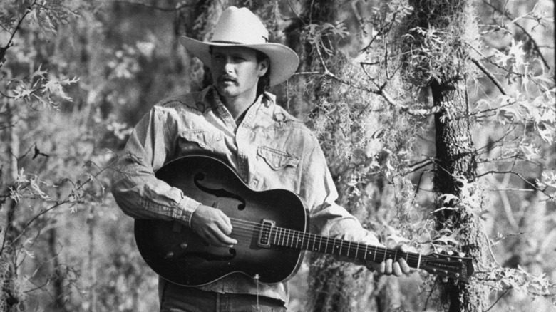 Black and white photo of Tim McGraw holding a guitar