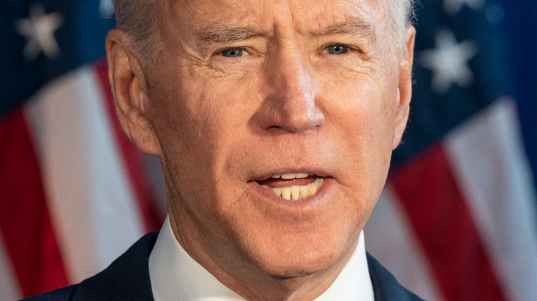 Joe Biden speaking in front of American flags