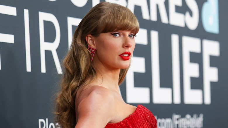 Taylor Swift posing over her shoulder on the red carpet.