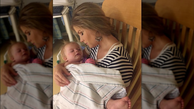 Erin Bates sleeping in a chair with her daughter Brooklyn Elise Paine.