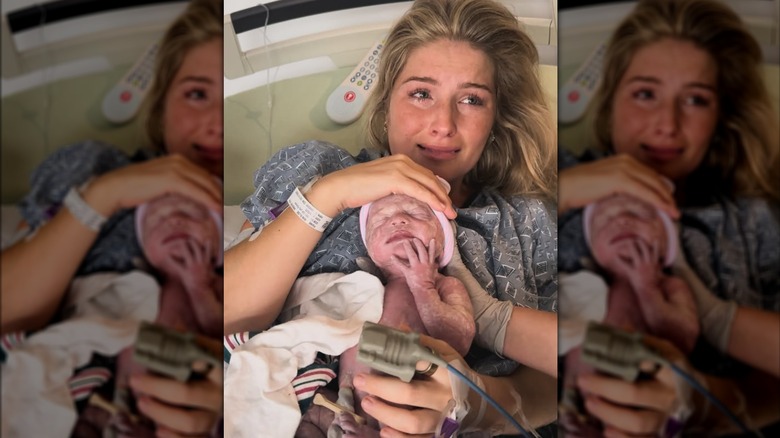 Erin Bates tearfully holding her newborn son Henry Blythe Paine.
