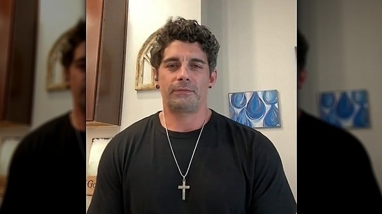Jason Alexander wearing a cross necklace during radio interview