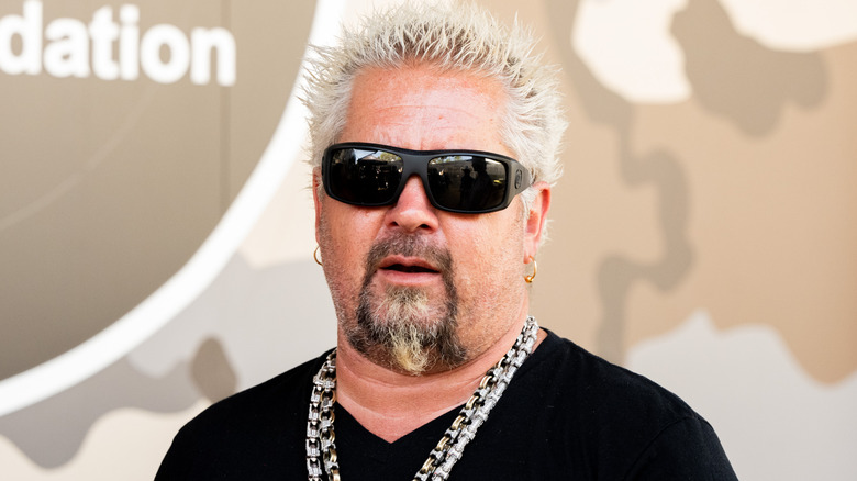 Guy Fieri posing for cameras in black shades