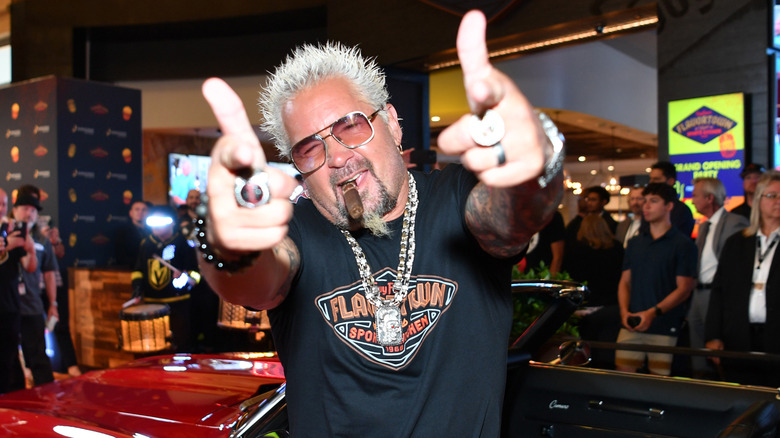 Guy Fieri posing for cameras with double finger guns