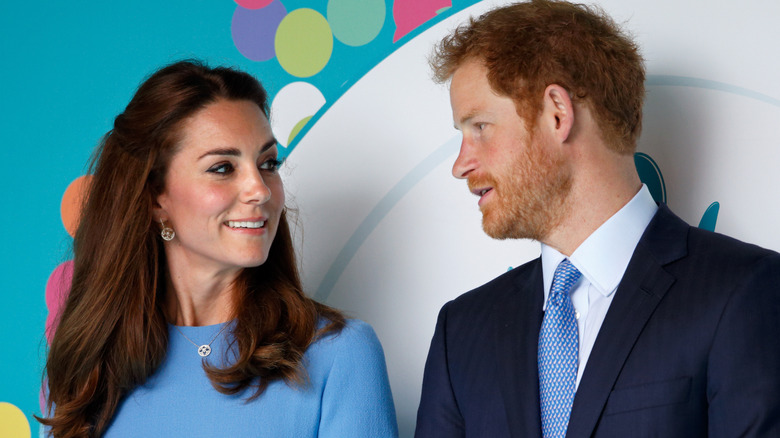 Kate Middleton and Prince Harry talking to one another at an event