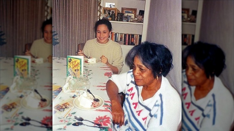 Young Meghan Markle eats cake at the table with her grandmother