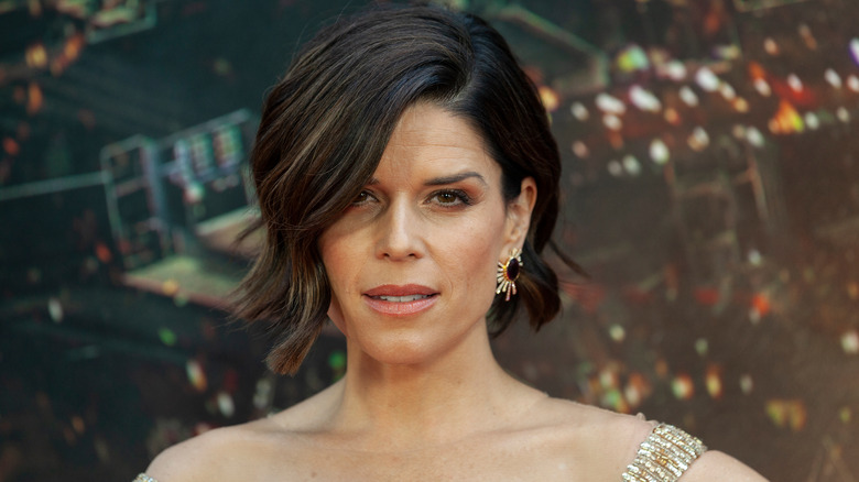 Neve Campbell wearing a gold dress on the red