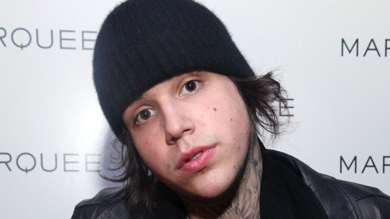 Richard Hilfiger posing for cameras on red carpet with a beanie
