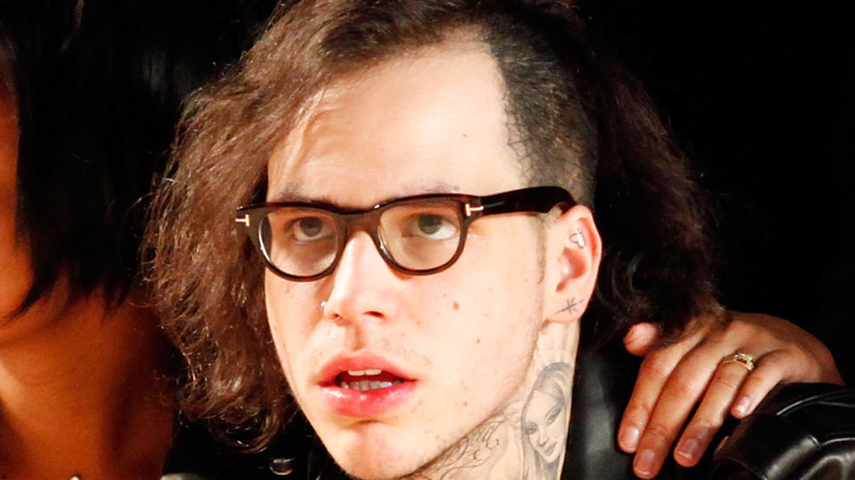 Richard Hilfiger attending a fashion show wearing glasses