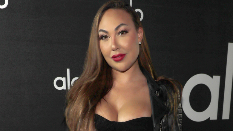 Celia Kay on red carpet wearing black dress and leather jacket