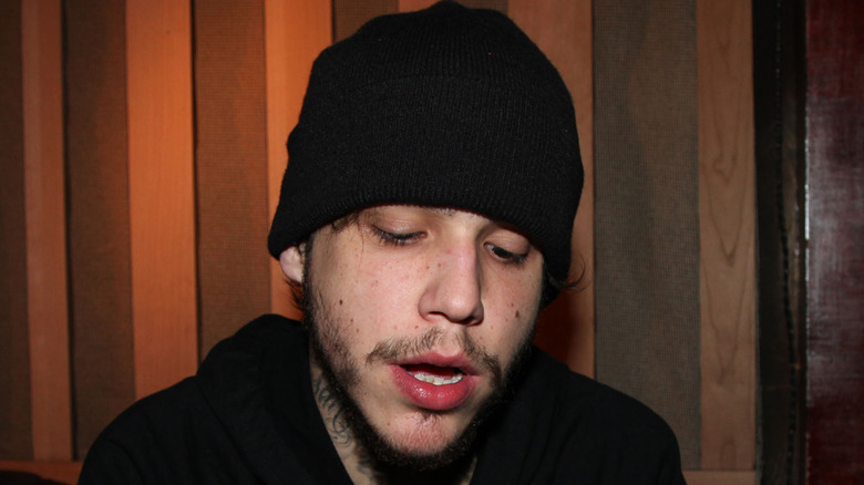 Richard Hilfiger posing for cameras looking scruffy in a beanie