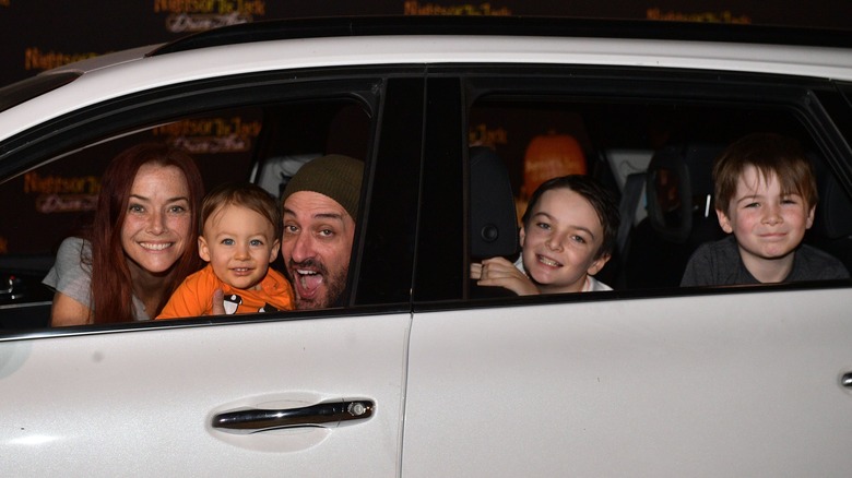 Annie Wersching, Stephen Full, and their sons, Freddie, Ozzie, and Archie sitting in a car and smiling at the camera