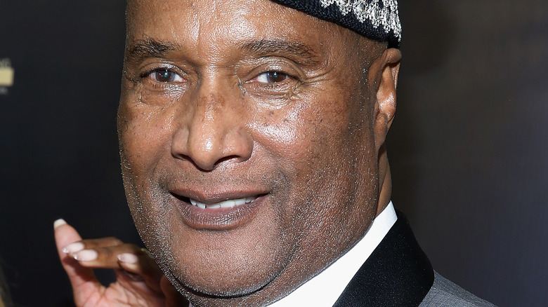 Paul Mooney smiles and poses