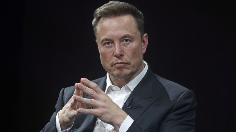 Elon Musk sitting on stage