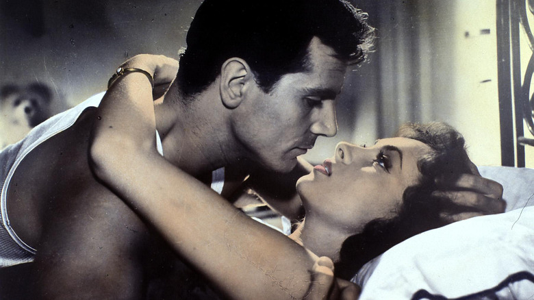 Gina Lollobrigida lying on bed staring into man's eyes