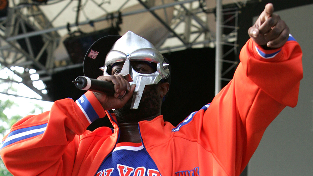 MF DOOM performs in an orange sweatshirt