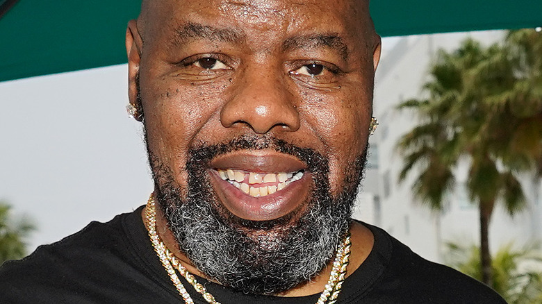 Rapper Biz Markie smiling in front of DJ booth