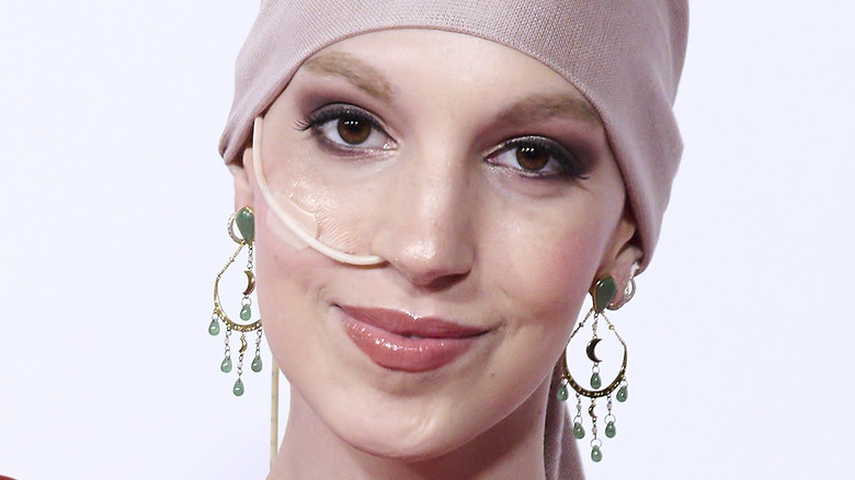 Elena Huelva wears jade dangle earrings