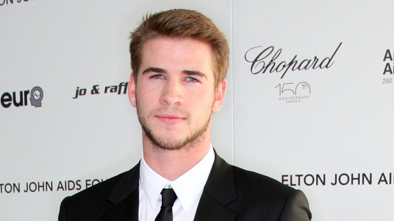 Liam Hemsworth looking serious suit