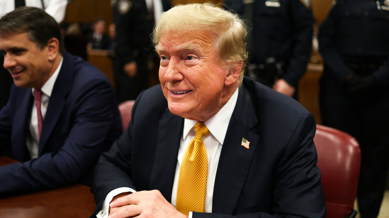 Donald Trump smiling in court.