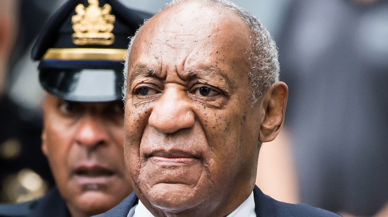 Bill Cosby flanked by police