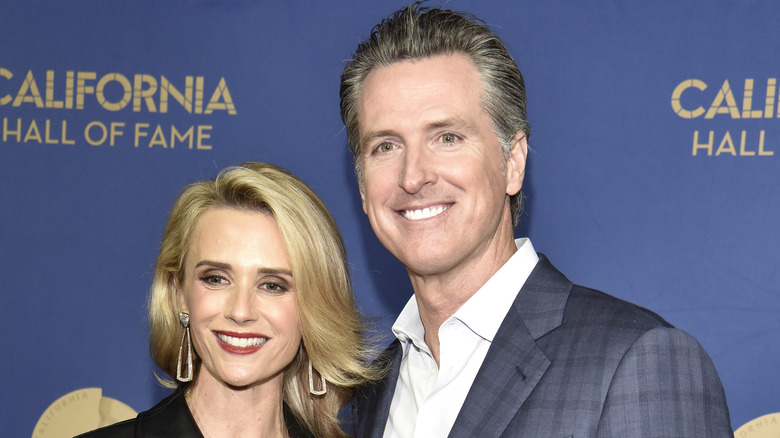 Jennifer Siebel Newsom and Gavin Newsom smile on a red carpet