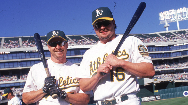 Jeremy Giambi and Jason Giambi holding bats