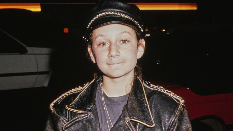 Sara Gilbert posing in a leather jacket in 1988