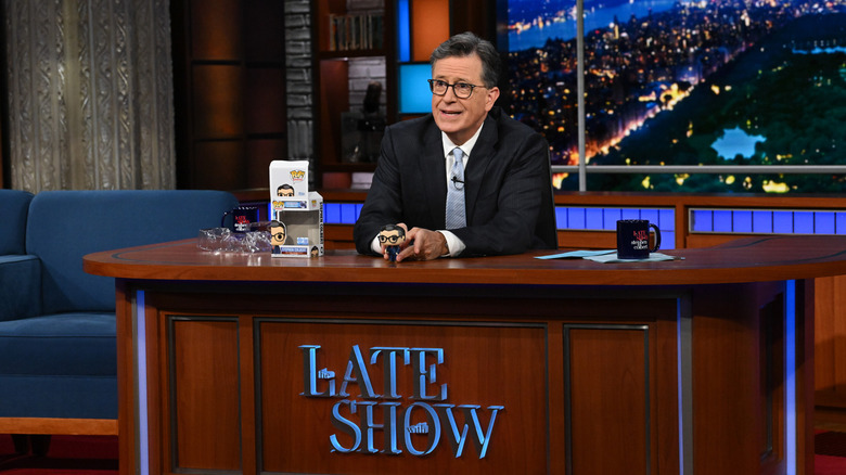 Stephen Colbert sitting at his Late Show desk