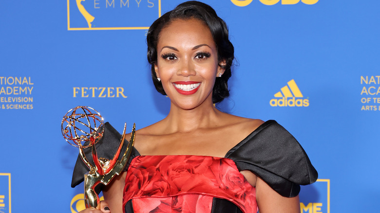 Mishael Morgan smiling, holding her Emmy