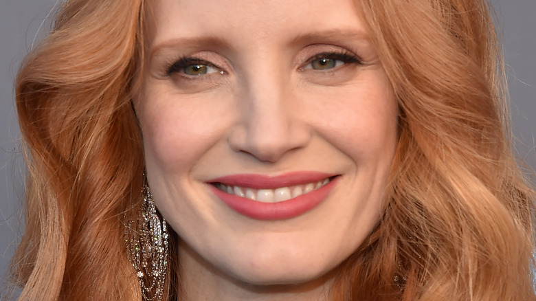 Jessica Chastain smiles with wavy hair down