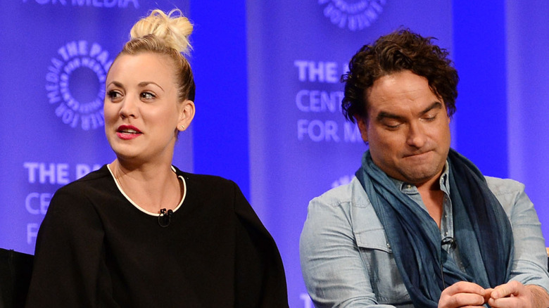 Kaley Cuoco and Johnny Galecki sitting on stage