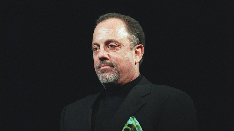 Billy Joel wearing a black tux with a green pocket square