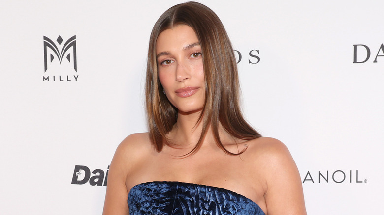 Hailey Bieber posing in a strapless top
