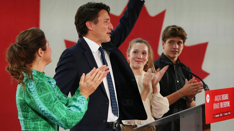 Ella-Grace Trudeau clapping onstage with her brother and parents
