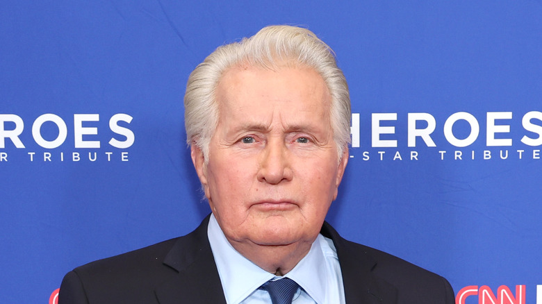 Martin Sheen standing in black suit