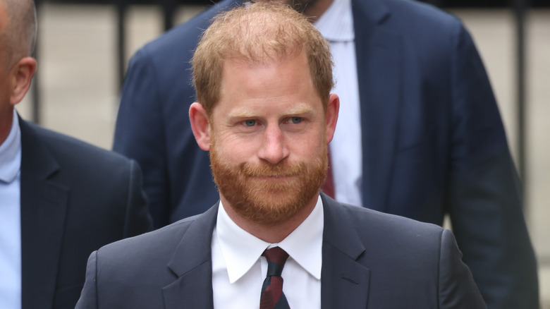 Prince Harry walking while wearing a suit