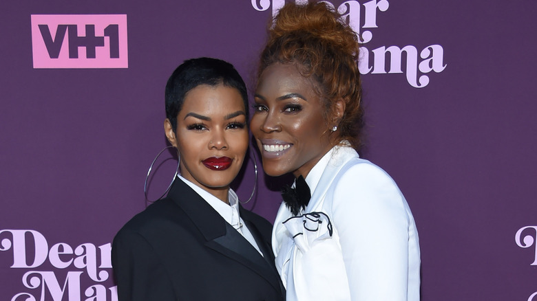 Teyana Taylor wearing large hoop earrings and posing with her mother, Nikki Taylor.
