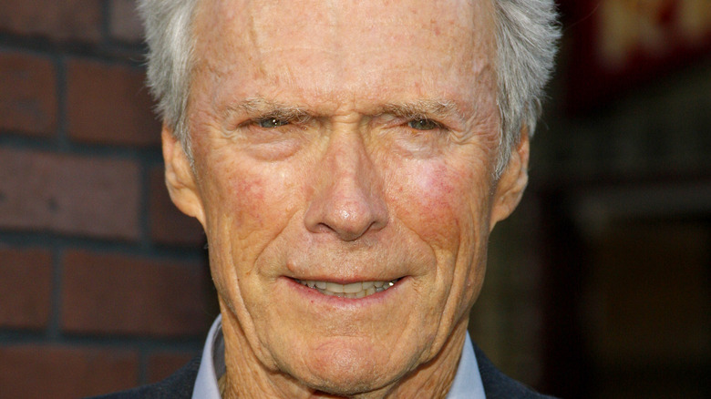 Clint Eastwood smiles in a suit.