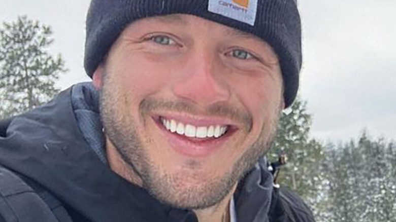 Colton Underwood smiling and wearing a winter hat