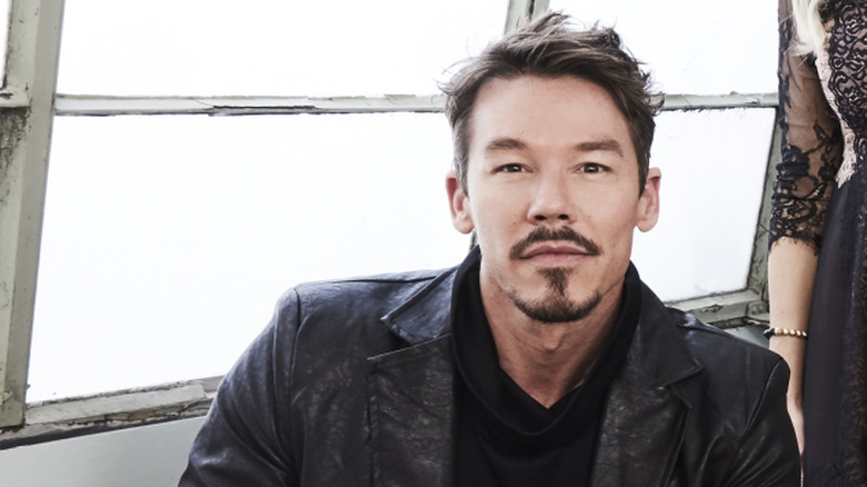 David Bromstad posing in front of a window while wearing a black leather jacket