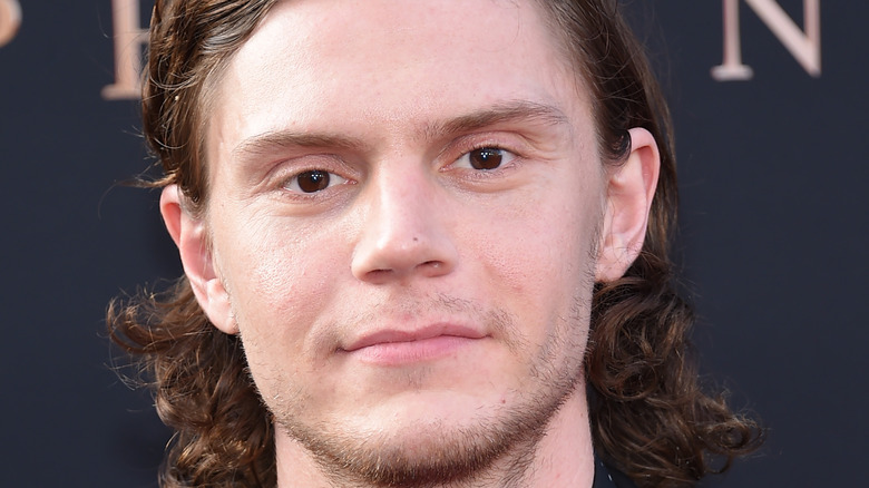 Evan Peters poses in a dark suit.