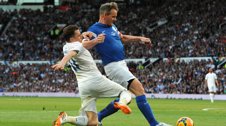 Danny Jones of England tackles Gordon Ramsay of the Rest of the World during Soccer Aid 2014