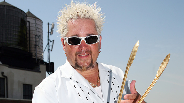 Guy Fieri holding tongs