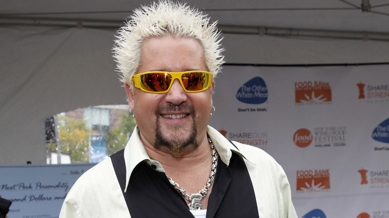 Guy Fieri wearing sunglasses, smiling