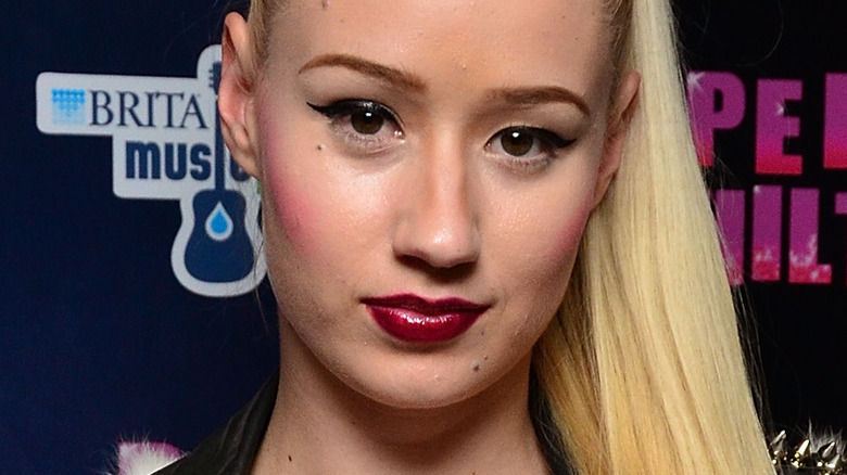 Iggy Azalea looking at camera with dark lipstick and ponytail