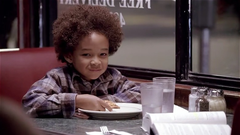 Jaden Smith grinning, seated in diner